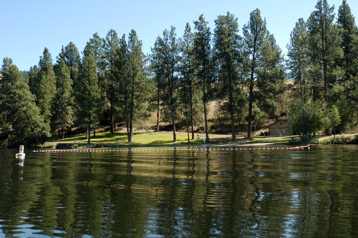 View of day-use area of Curlew Lake State Park from Curlew Lake. The area includes a designated swim area. 